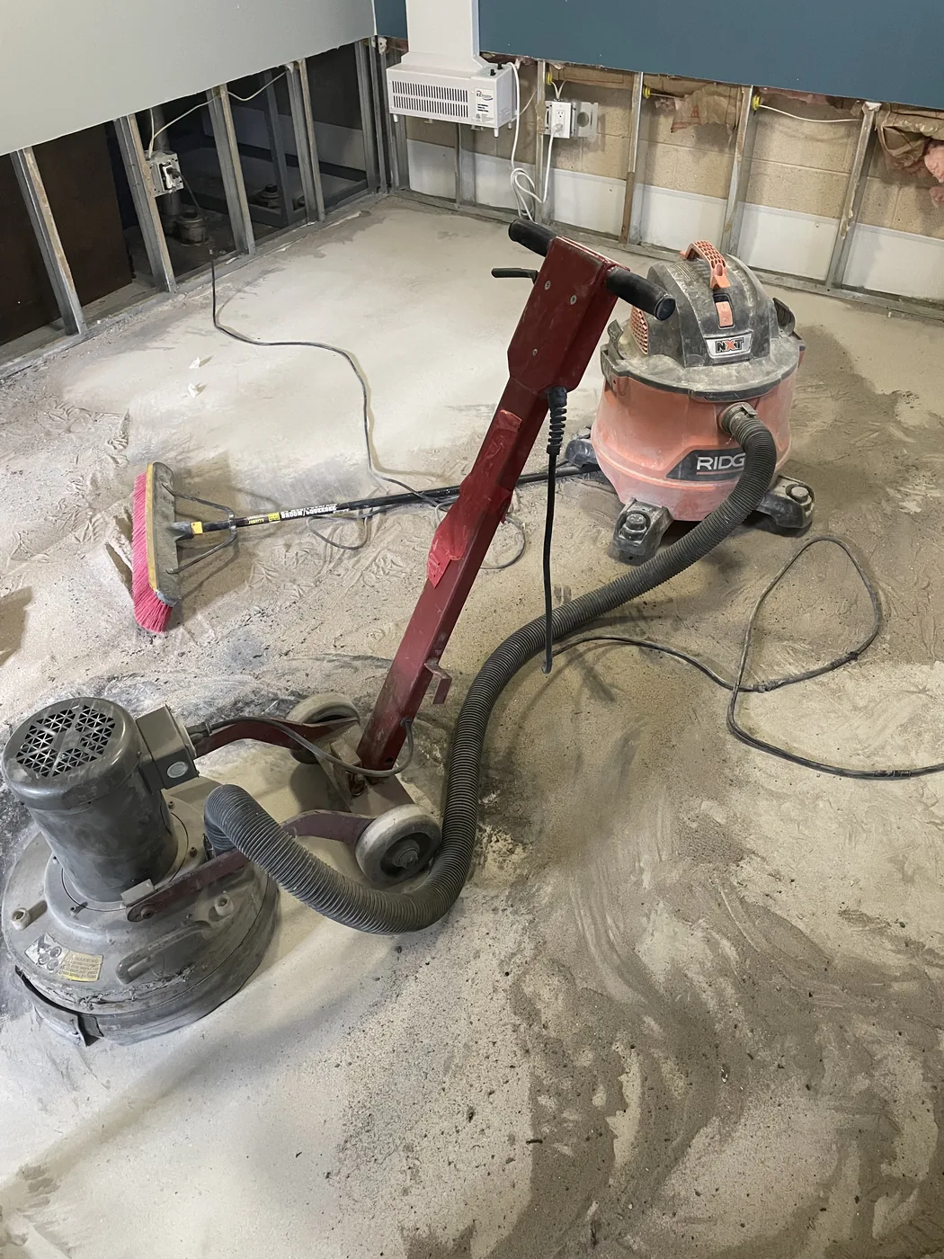 Concrete floor being mechanically prepared before epoxy coating